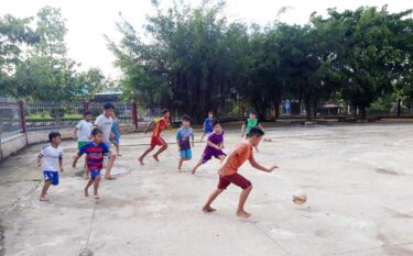裸足でサッカーをするベトナムの子ども